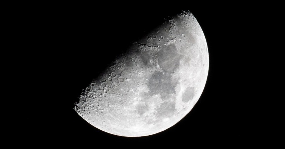 A moon peaking from the shadows.